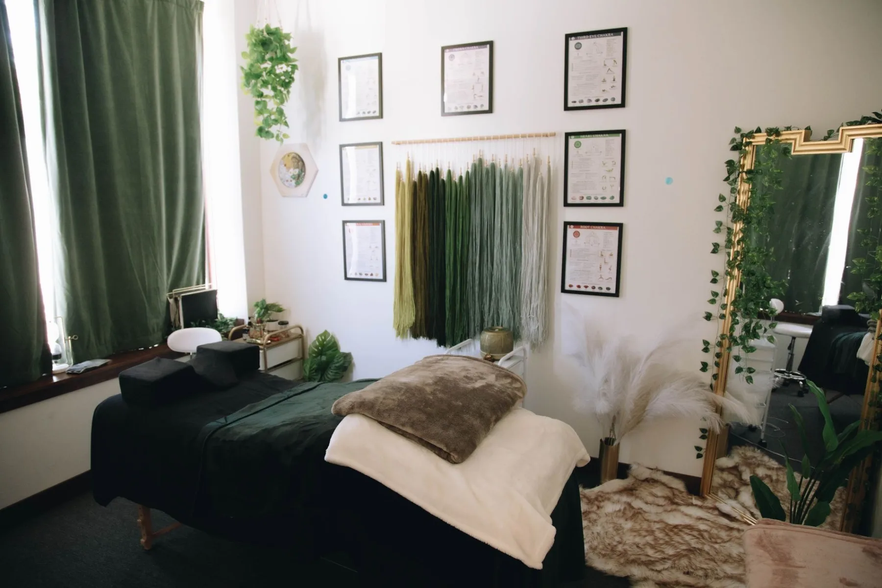 The Root and Rise treatment room with a massage table and leafy details